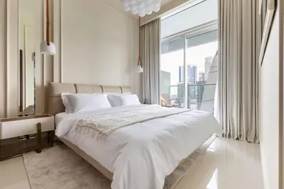 a white bedroom with a large bed and a large window at Glamorous 1Bedroom in Business bay l Large Balcony in Dubai