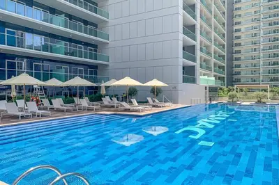 a large swimming pool with chairs and a building at Glamorous 1Bedroom in Business bay l Large Balcony in Dubai