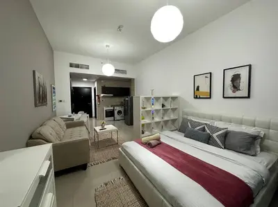 a bedroom with a large bed and a living room at Cozy Studio- Dubai Marina in Dubai