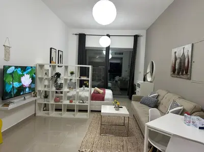 a living room with a couch and a tv at Cozy Studio- Dubai Marina in Dubai
