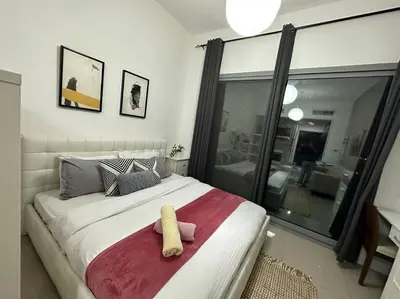 a bedroom with a large bed with a yellow towel on it at Cozy Studio- Dubai Marina in Dubai
