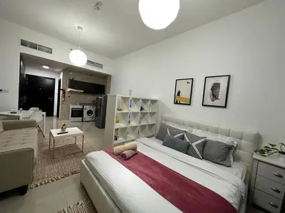 a bedroom with a large bed and a living room at Cozy Studio- Dubai Marina in Dubai