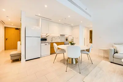 a kitchen and living room with a table and chairs at Luxe 1BD apartment in La Vie with beach access in Dubai