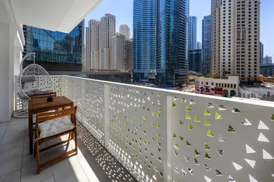 a balcony with a white railing with green birds on it at Luxe 1BD apartment in La Vie with beach access in Dubai