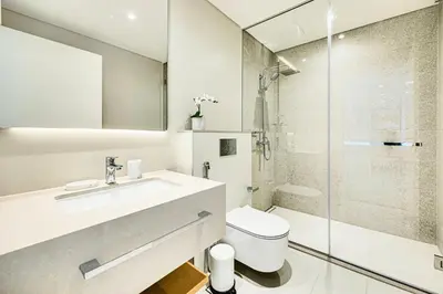 a bathroom with a toilet and a sink and a shower at Luxe 1BD apartment in La Vie with beach access in Dubai