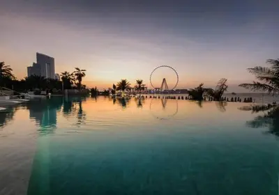 a large pool of water with a ferris wheel in the background at Luxe 1BD apartment in La Vie with beach access in Dubai