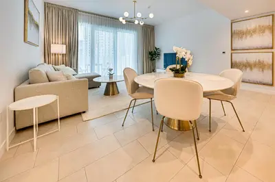 a living room with a table and chairs and a couch at Luxe 1BD apartment in La Vie with beach access in Dubai