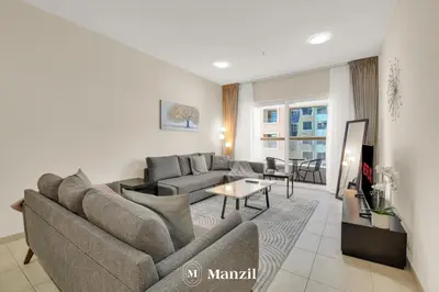 a living room with a couch and a table at Manzil - 1BR in Elite Residence with Marina View in Dubai