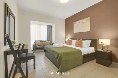 a bedroom with a bed and a chair and a desk at Manzil - 1BR in Elite Residence with Marina View in Dubai