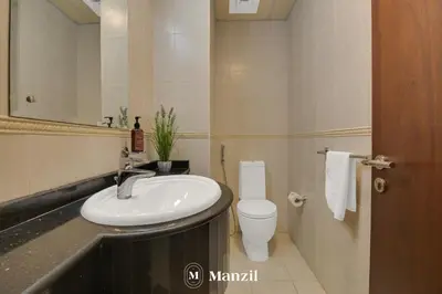 a bathroom with a sink and a toilet and a mirror at Manzil - 1BR in Elite Residence with Marina View in Dubai
