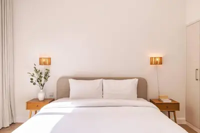 a bedroom with a large white bed with two tables at Downtown Oasis Luxury One-bed in Downtown Dubai in Dubai