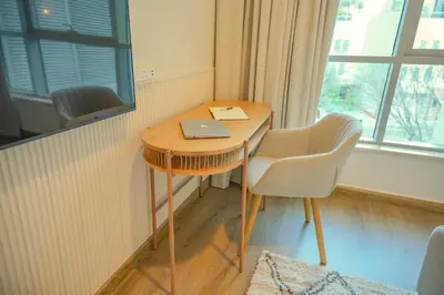 a desk with a laptop on it next to a window at Downtown Oasis Luxury One-bed in Downtown Dubai in Dubai