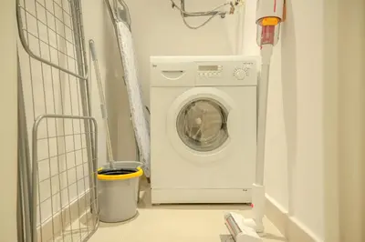 a washing machine in a laundry room with a trash can at Downtown Oasis Luxury One-bed in Downtown Dubai in Dubai