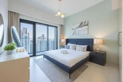 a bedroom with a large bed and a large window at Burj Royale - Central Two Bedroom in Dubai