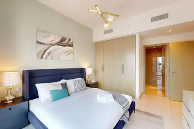 a bedroom with a large bed with a blue headboard at Burj Royale - Central Two Bedroom in Dubai