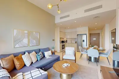 a living room with a blue couch and a table at Burj Royale - Central Two Bedroom in Dubai