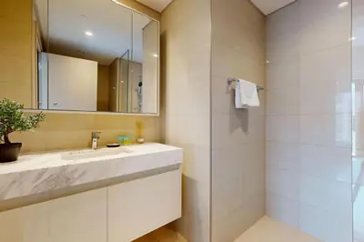 a bathroom with a sink and a mirror and a shower at Burj Royale - Central Two Bedroom in Dubai