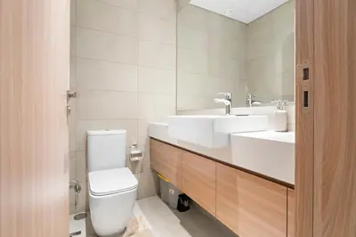 a bathroom with a toilet and a sink at Beautiful 1 BR with Gym, Pool & Kid's Playground in Dubai