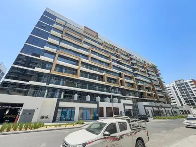 a car parked in front of a tall building at Beautiful 1 BR with Gym, Pool & Kid's Playground in Dubai
