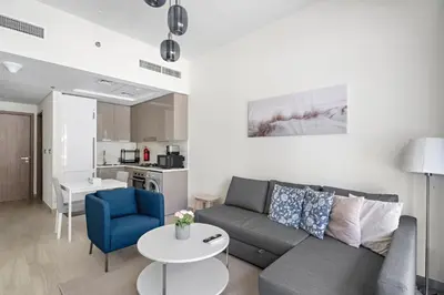 a living room with a couch and a table at Beautiful 1 BR with Gym, Pool & Kid's Playground in Dubai