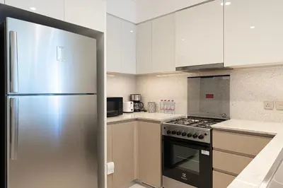 a kitchen with a stainless steel refrigerator and white cabinets at Stunning 2BR Full Burj Khalifa Views 5min walk to Dubai Mall in Dubai