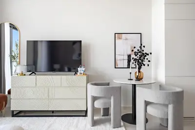 a dining room with a table and chairs and a dresser at Silkhaus New High Floor Studio In Business Bay in Dubai