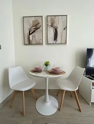 a table and two chairs in a room with paintings at Modern studio view Burj Khalifa in Dubai