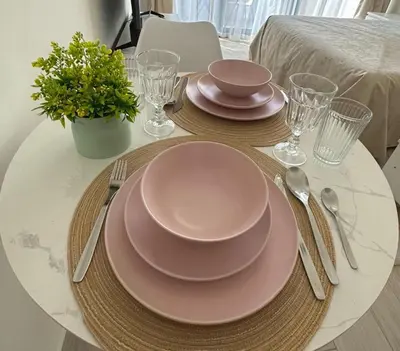 a table with pink plates and utensils on it at Modern studio view Burj Khalifa in Dubai