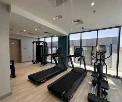 a gym with treadmills and ellipticals in a building at Modern studio view Burj Khalifa in Dubai