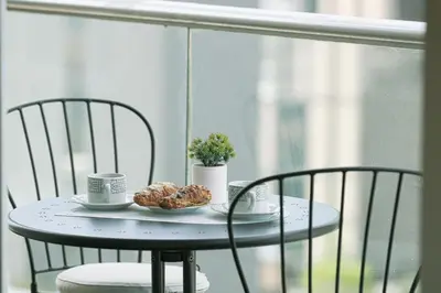 a table with two chairs and a plate of donuts on a balcony at Stunning Burj and Fountain View - 2BR in Dubai