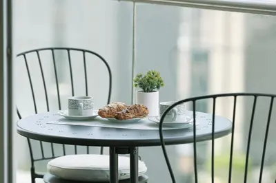 a table with two chairs and a plate of donuts on it at Stunning Burj and Fountain View - 2BR in Dubai