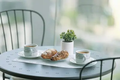 two cups of coffee and two pastries on a table at Stunning Burj and Fountain View - 2BR in Dubai