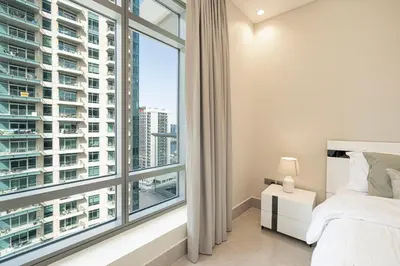 a bedroom with a bed and a large window at Stunning Burj and Fountain View - 2BR in Dubai