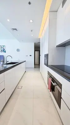 a white kitchen with a sink and a stove at Spectacular Lagoon Apartment in Dubai