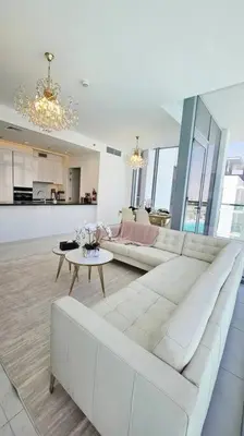 a living room with a white couch and a table at Spectacular Lagoon Apartment in Dubai