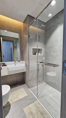 a bathroom with a shower and a toilet and a sink at Spectacular Lagoon Apartment in Dubai