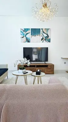 a living room with two tables and a television at Spectacular Lagoon Apartment in Dubai
