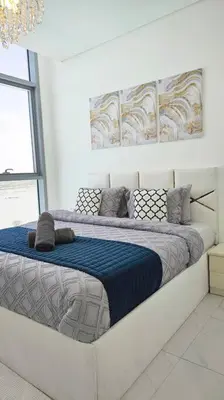 a bedroom with a large bed with a blue blanket at Spectacular Lagoon Apartment in Dubai