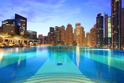 a large swimming pool in front of a city skyline at One bedroom apartment in JW Marriott Hotel Dubai Marina in Dubai