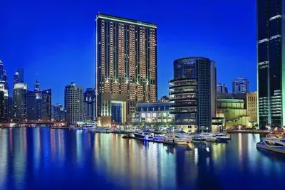 a city skyline with boats in the water at night at One bedroom apartment in JW Marriott Hotel Dubai Marina in Dubai
