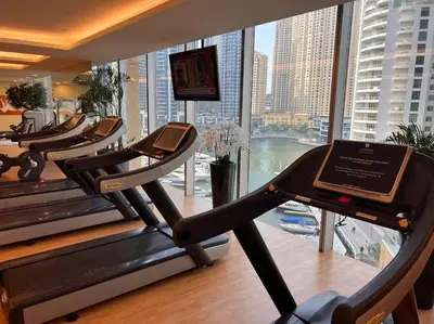 a gym with a row of cardio machines and a large window at One bedroom apartment in JW Marriott Hotel Dubai Marina in Dubai