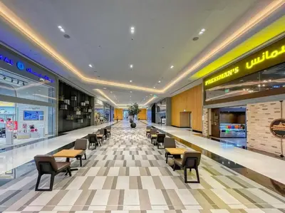 a shopping mall with tables and chairs in the middle at First Class 1BR Modern & Stylish Living in Dubai