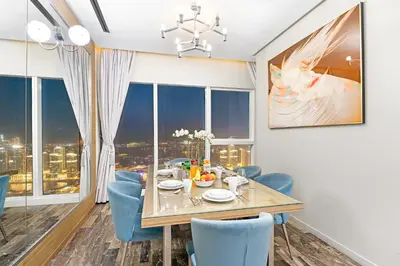 a dining room with a table and blue chairs at Dubai 2BR Flat, Marina Views, Pool Access, Parking, Walk to Mall in Dubai