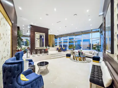 a large lobby with blue chairs and tables at Dubai 2BR Flat, Marina Views, Pool Access, Parking, Walk to Mall in Dubai
