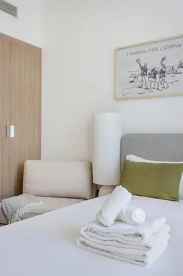 a bedroom with a bed with white towels on it at Lux Stu Bright Urban Escape Stay Near Downtown in Dubai
