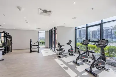 a gym with treadmills and elliptical machines at Lux Stu Bright Urban Escape Stay Near Downtown in Dubai