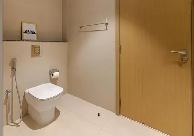a bathroom with a toilet and a wooden door at Downtown Views 4702 in Dubai