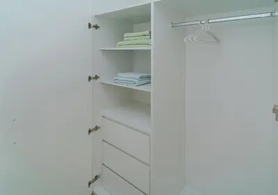 a white closet with white drawers and towels at Downtown Views 4702 in Dubai