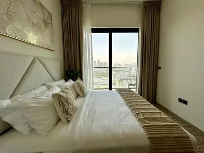 a bedroom with a large bed with a large window at Cozy Elegant 1br Balcony, Pool Access, Parking in Dubai