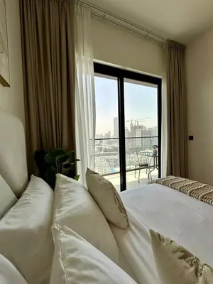 a bedroom with a bed and a window with a view at Cozy Elegant 1br Balcony, Pool Access, Parking in Dubai